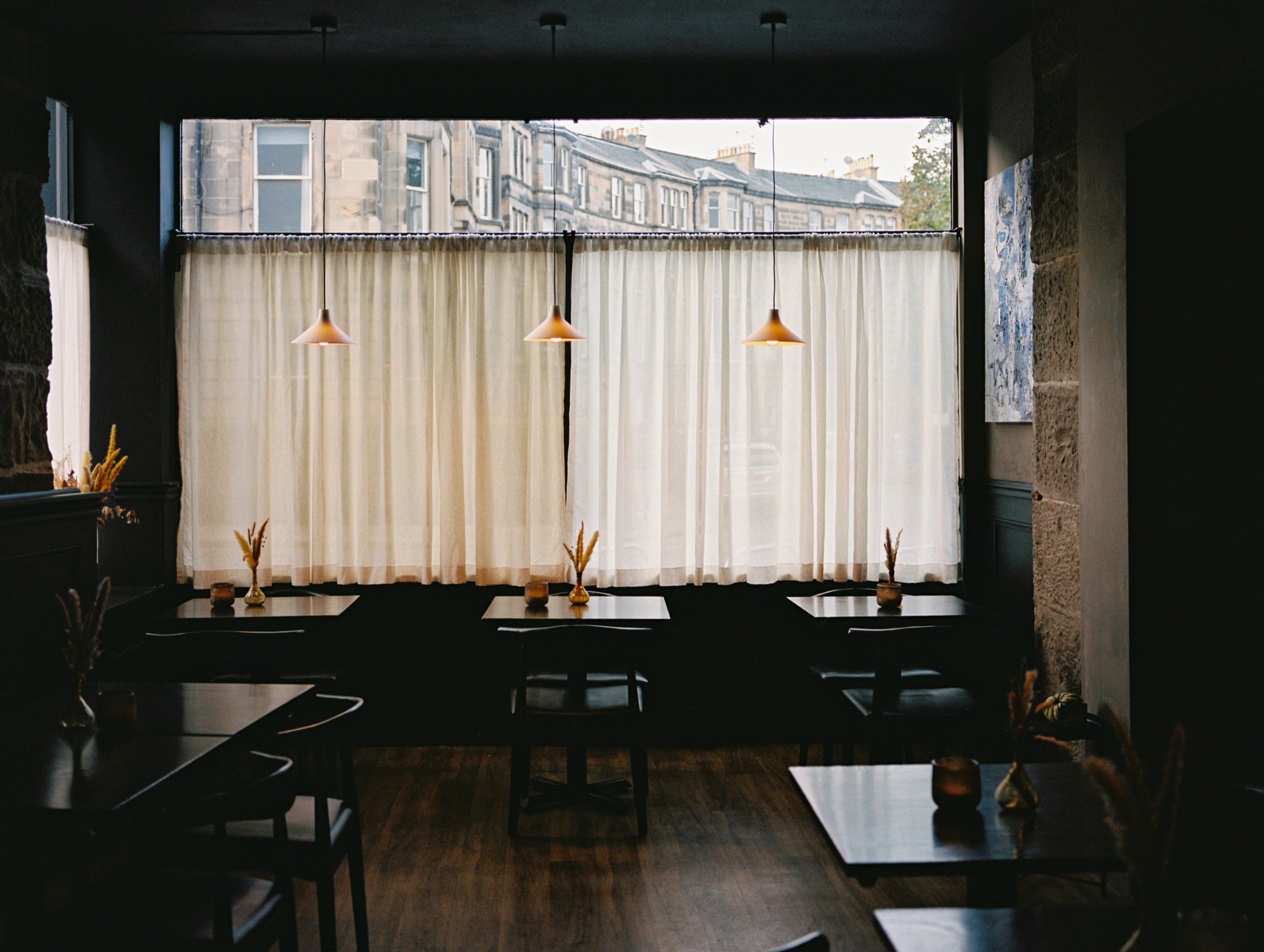 The Cardinal dining room, tables set beneath the curtained window